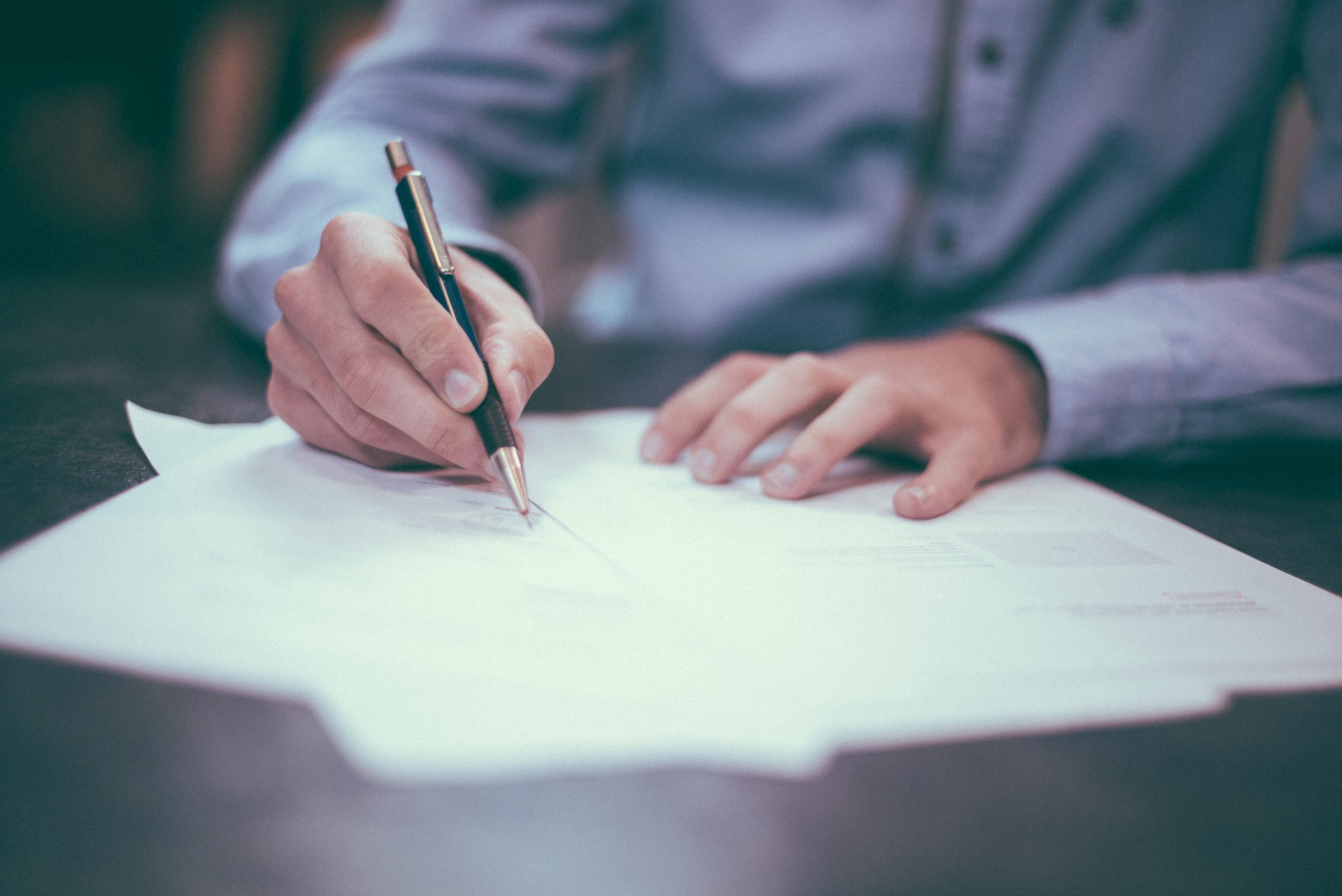 Man signing forms on a desk